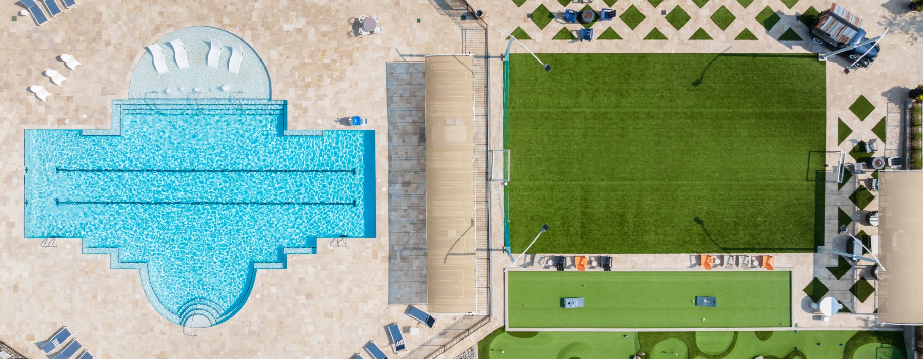 Aerial view of pool, mini golf course, and turf flex fields at Blu South townhome apartments near Charlotte